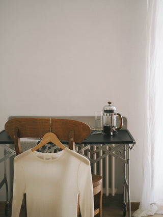 A neatly repaired cashmere garment displayed on a table, emphasising the seamless and invisible mending process