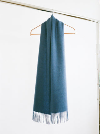 Petrol blue cashmere woven scarf with a smooth, slightly shiny finish and fringed ends